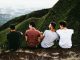 Four guys friends sitting on mountain top