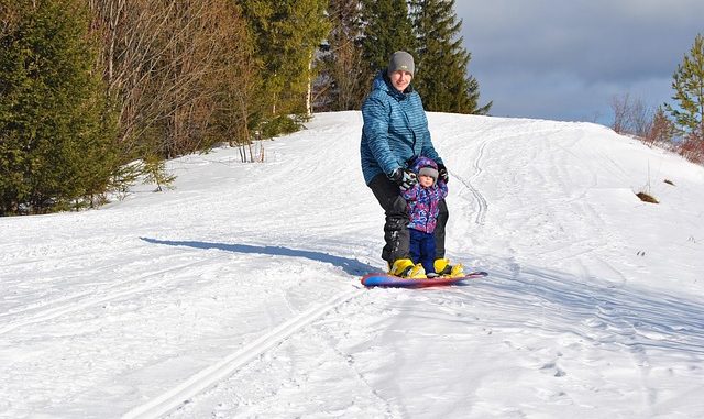 Man and child on a snowboard