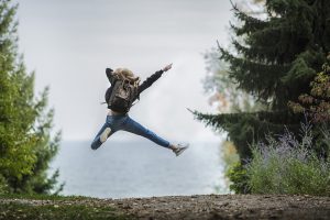 Woman jumping for joy outdoors, full of health and resilience