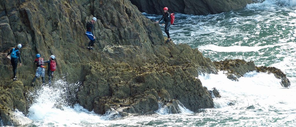 Group coasteering on the cliffs by the sea