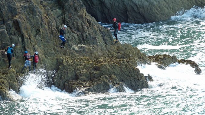 coasteering Group coasteering on the cliffs by the sea
